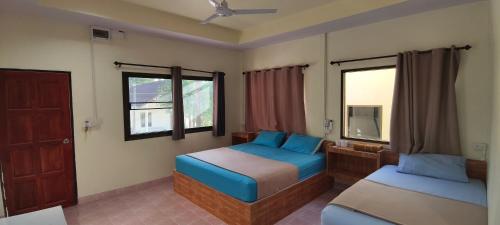 a bedroom with two beds and a window at Happy Bungalow in Ko Tao