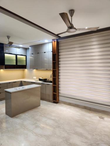 a kitchen with a ceiling fan and a wall with sliding doors at Thecomfortden in Sohāna