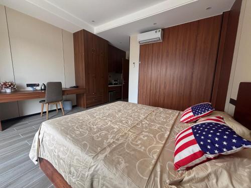 a bedroom with a bed with an american flag on it at D02 - Happy Beach Villas - No2 Căn hộ Z&Z Triple key - NovaWorld Ho tram in Binh Chau