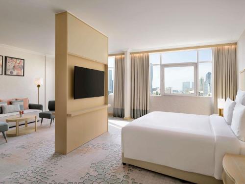 a hotel room with a bed and a television at Swissôtel Al Murooj Dubai in Dubai
