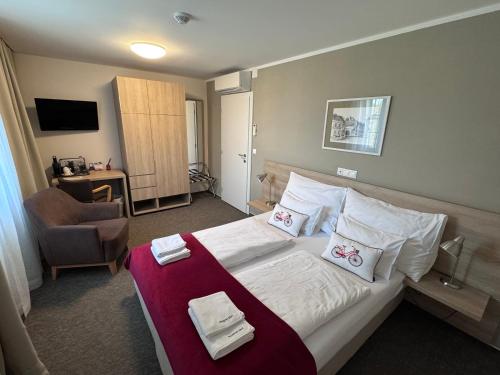 a hotel room with a bed and a chair at Sonjas Auszeit in Rust