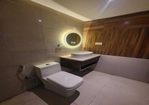 a bathroom with a white toilet and a sink at Hotel Ananta Vilas in Khurja