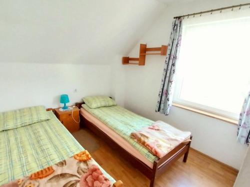 a bedroom with two beds and a window at Wypoczynek Kocia Góra in Dziemiany