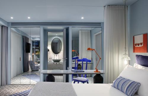 a bedroom with a bed and a desk and a mirror at Fresh Hotel, a member of Design Hotels in Athens