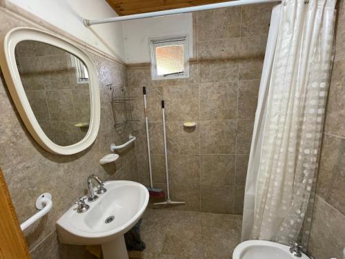 a bathroom with a sink and a mirror and a shower at Cabañas El Muelle in Cholila