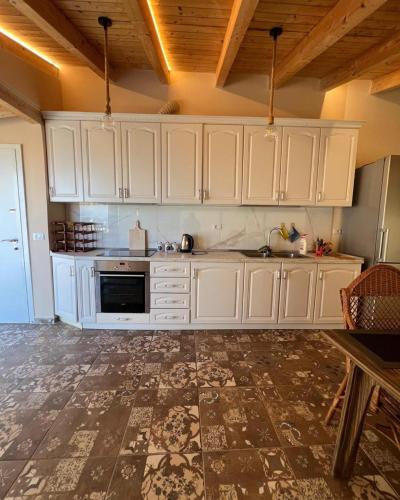 a kitchen with white cabinets and a tile floor at Sea View Penthouse in Durrës