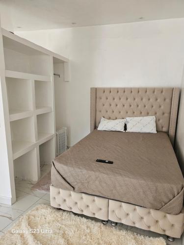 a bedroom with a large bed with a large headboard at Emmanuel INN XI in Pierrefitte-sur-Seine