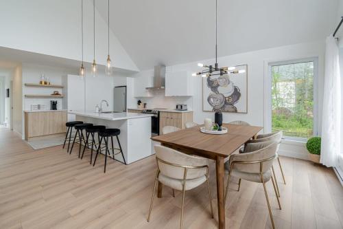 a kitchen and dining room with a wooden table and chairs at Dahlia #1 - Spa & Pets in Valcartier Station