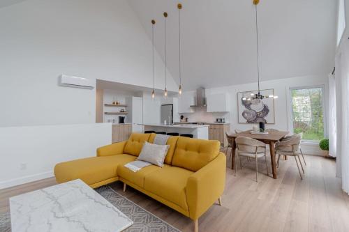 a living room with a yellow couch and a kitchen at Dahlia #1 - Spa & Pets in Valcartier Station