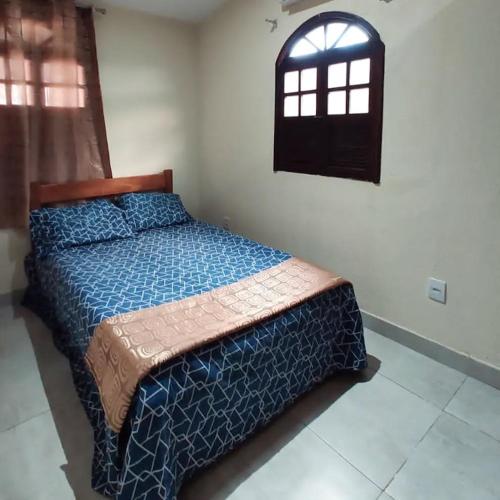 a bedroom with a bed and a window at Funcional, cômoda e confortável in Camaçari