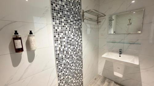 a white bathroom with a sink and a mirror at 花一村の宿 Huayicun Homestay in Hengchun South Gate