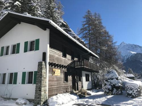 a house in the snow with snow covered trees at Chalet 12 Cerfs in Evolène