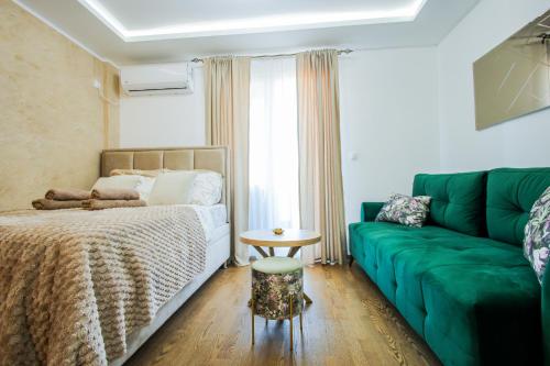 a bedroom with a bed and a green couch at Panorama V Lux Vrnjačka Banja in Vrnjačka Banja