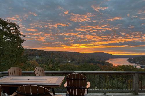 a table and chairs on a deck with a sunset at Rocky Mountain Lodge by Railey Vacations in McHenry
