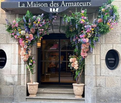 an entrance to a building with flowers on it at La Maison des Armateurs in Saint Malo