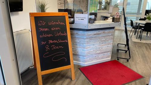 a chalkboard sign in front of a restaurant at Appartementhaus Ostseeresidenz in Heiligenhafen