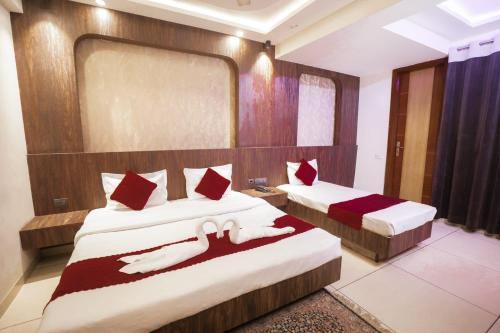 a bedroom with two beds with red pillows at Hotel AR Residency in New Delhi