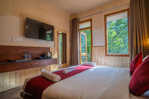a bedroom with a large bed with a tv on the wall at New Armadale Nainital in Nainital