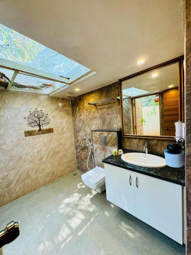 a bathroom with a sink and a toilet and a mirror at Airyaman Hollistic Hive in Narasimharaja Puram