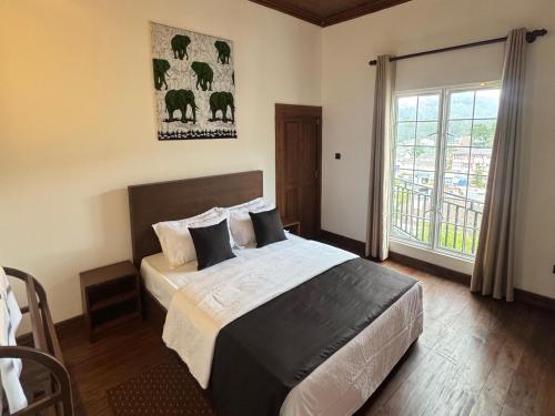 ein Schlafzimmer mit einem Bett und einem großen Fenster in der Unterkunft Star Gate in Nuwara Eliya