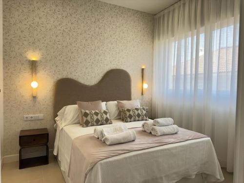 a bedroom with a large bed with towels on it at Apartamentos Las Mereras in Fuente Palmera