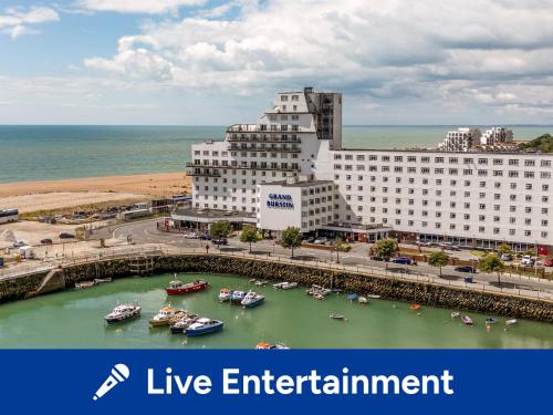 a large white building with boats in a harbor at The Grand Burstin Hotel in Folkestone