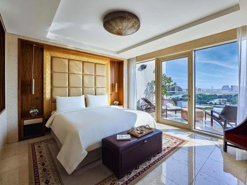 a bedroom with a large bed and a large window at Raffles Dubai in Dubai