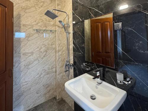 ein Badezimmer mit Waschbecken und Dusche in der Unterkunft Star Gate in Nuwara Eliya