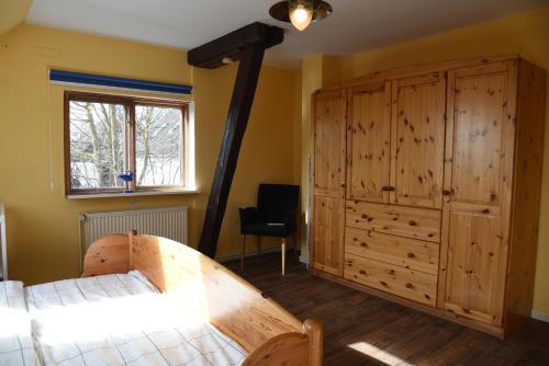 a bedroom with a bed and a large wooden cabinet at Ferienwohnung Ankerpladsen Opti in Behrensdorf