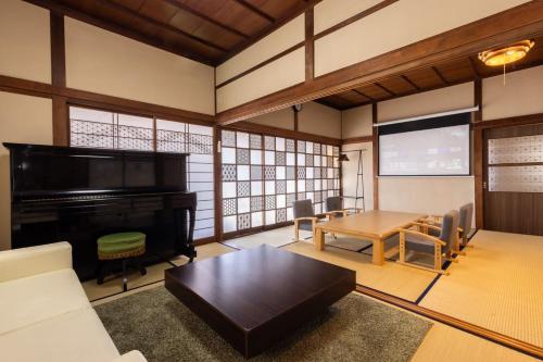 a living room with a piano and a table at Irest Village Matsumoto in Matsumoto