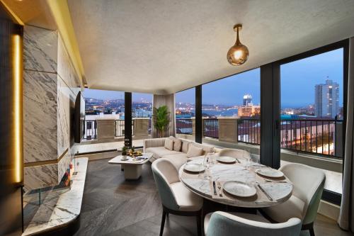 un salon avec une table et des chaises et de grandes fenêtres dans l'établissement Bentley Hotel Bosphorus - Special Class, à Istanbul