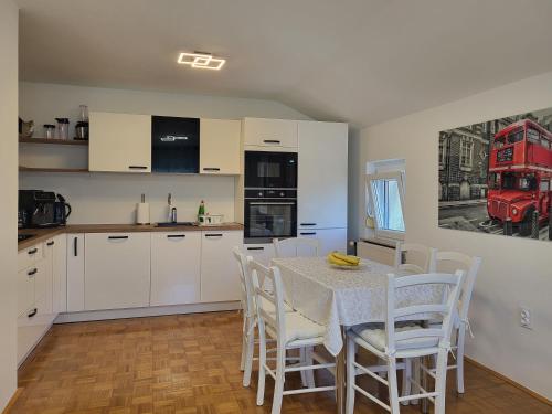 a kitchen with a table and chairs and a red bus at Apartma Peric in Ljubljana