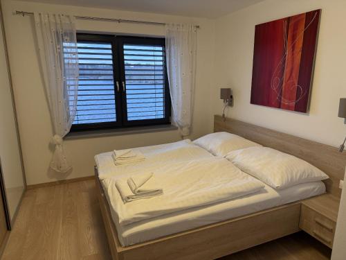 a large bed in a room with a window at Vila 512 priamo pri jazere in Šajdíkove Humence