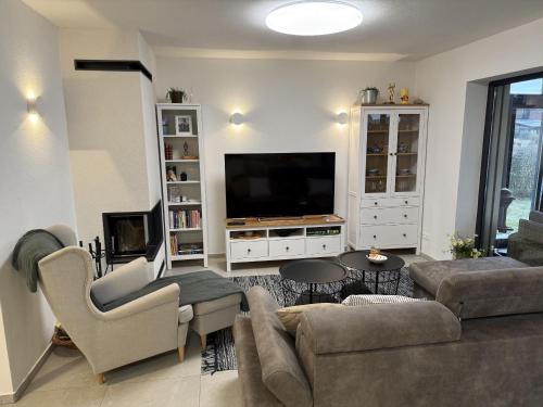 a living room with a couch and a tv at Vila 512 priamo pri jazere in Šajdíkove Humence