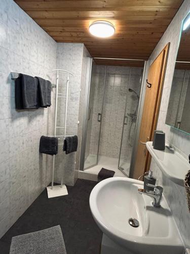 a white bathroom with a shower and a sink at Fagererhof in Bad Reichenhall