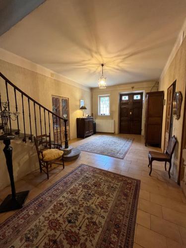a living room with a staircase and a rug at Les 3 Platanes in Conilhac-Corbières