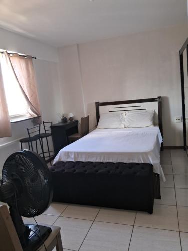 a bedroom with a bed and a fan in it at Studio Playcenter in Campos dos Goytacazes