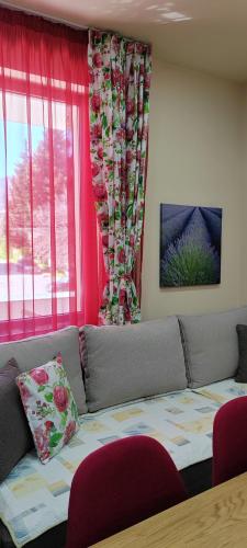 a living room with a couch and a window at Stylish Rose Garden Apartment with Balcony & Parking in Asenovgrad