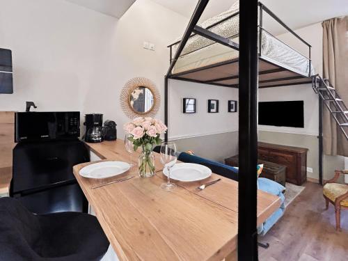 a room with a dining table and a loft bed at Superbe Grand Studio dans le vieux Tours avec fraicheur au rendez-vous in Tours
