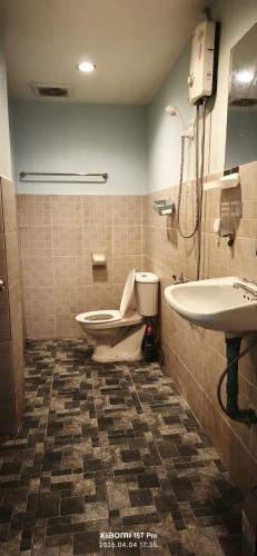 a bathroom with a toilet and a sink at Redbull guest house in Pattaya