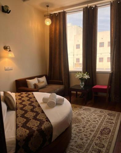 a bedroom with a bed and a couch and a window at Hotel WoodCresstt Zirakpur !! Budget Friendly Stay With Airport Access in Zirakpur