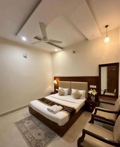 a bedroom with a bed with a ceiling fan and a chair at Hotel WoodCresstt Zirakpur !! Budget Friendly Stay With Airport Access in Zirakpur
