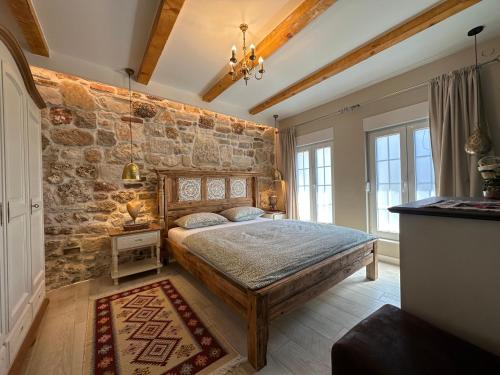 ein Schlafzimmer mit einer Steinwand und einem großen Bett in der Unterkunft Apartments Villa Mike in Mostar