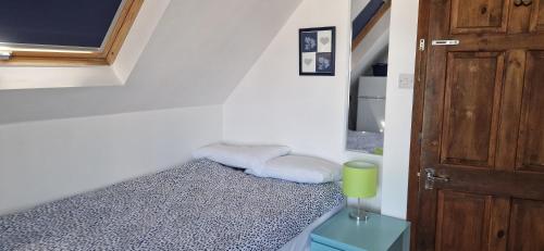 a small room with a bed and a window and a door at Chezzas Homestay in Poole