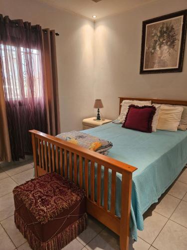 a bedroom with a bed with a blue comforter at Mathildah's Appartements in Libreville