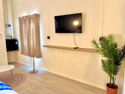 a living room with a tv on a wall at Sunvada Beach Rayong in Rayong