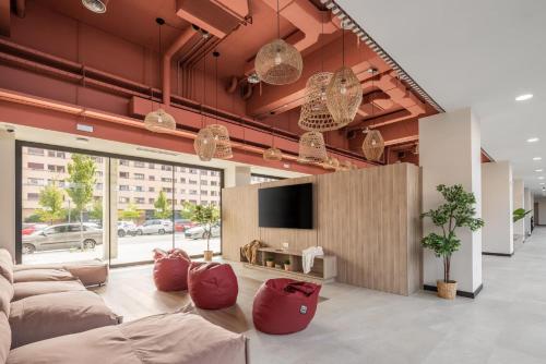 a room with couches and a flat screen tv at Amro Pamplona - Albergue Juvenil in Pamplona