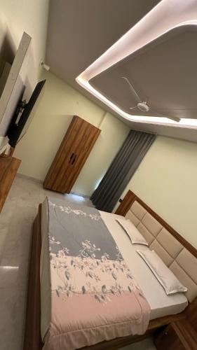 a bedroom with a bed with a ceiling at Mangalam Palace Vrindavan in Chhatikara