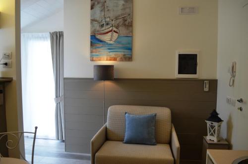 a living room with a chair and a painting at Appartamenti Barzilai in Gabicce Mare