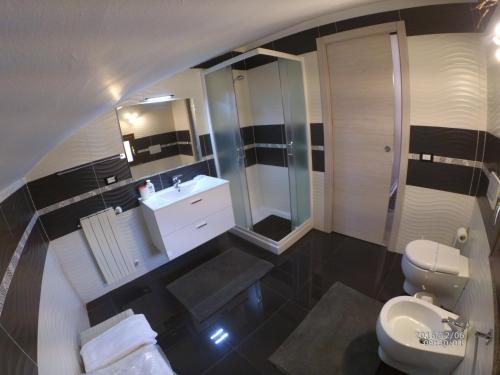 a bathroom with a sink and a toilet and a mirror at Casa Vacanze Volpe Dell'Etna in Nicolosi